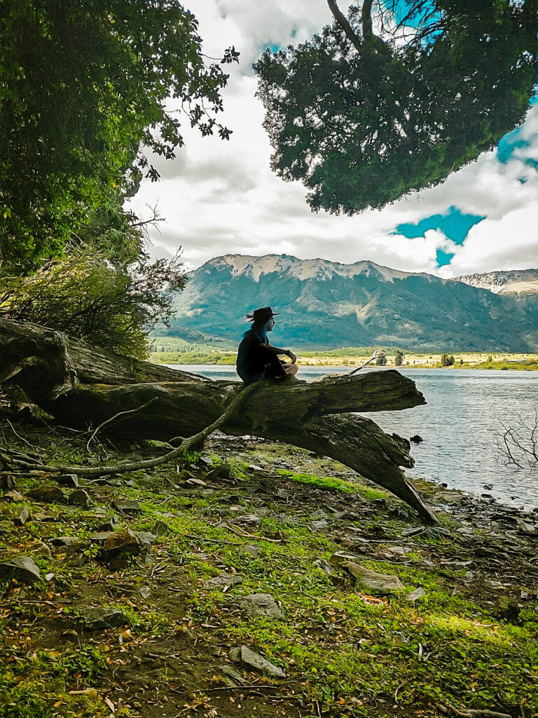Sentado sobre un tronco a orillas del lago Huachulafquen